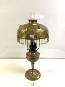 ART NOUVEAU EMBOSSED BRASS OIL LAMP, CONVERTED TO ELECTRIC, THE BRASS SHADE INSET WITH GLASS