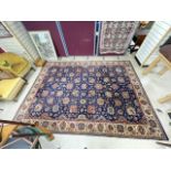 A GERMAN MACHINE-MADE BLUE GROUND FLORAL KESHAN STYLE RUG (250 X 350CMS)