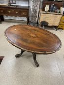 ANTIQUE OVAL TILT TOP TABLE WITH CARVED EDGES AND CARVED PEDESTAL BASE MARQUETRY INLAY TO TOP (134 X