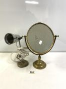 1960S ALUMINUM TABLE LAMP ON AN IRON BASE, WITH AN OVAL BRASS SWING FRAME VANITY MIRROR