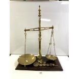 A LARGE SET OF VICTORIAN BRASS BALANCE SCALES AND SOME WEIGHTS ON A WOODEN BASE - MADE BY WINSBURY &