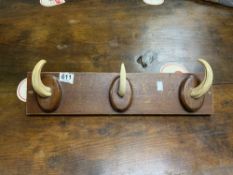 A WOODEN AND HOG TASK WALL MOUNTED COAT RACK