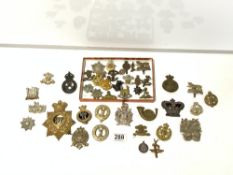 A QUANTITY OF REPLICA MILITARY CAP BADGES, AND A CROWN PATCH.