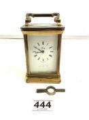 A BRASS CARRIAGE CLOCK TIMEPIECE BY HENLEY CLOCK COMPANY WITH KEY