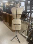 A VINTAGE DRESS MAKERS DUMMY ON METAL BASE, MODELLIUNG A BLUE AND WHITE DRESS.
