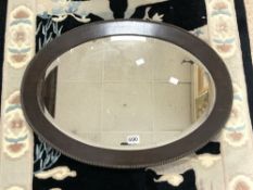 OVAL OAK FRAMED BEVELLED WALL MIRROR WITH BEADED DECORATION TO RIM. 72X51 CMS.