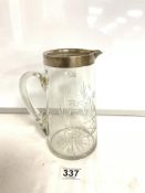 A CUT GLASS WATER JUG WITH A HALLMARKED SILVER RIM. BIRMINGHAM 1919, JOHN GRINSELL AND SONS. 20CMS.