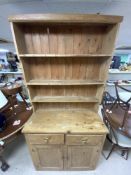 A STRIPPED PINE DRESSER WITH PLATE RACK, TWO DRAWERS OVER CUPBOARD BASE. 104X44X216 CMS.