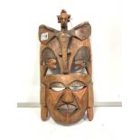 AN INTRICATELY CARVED AND DECORATED MASK FEATURING AN ANTHROPOMORPHIC ELEPHANT FIGURE TO THE TOP,