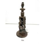 A WOODEN TABLE LAMP WITH CARVED SCENE DEPICTING TWO FIGURES, 36CM HIGH