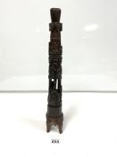AN HARDWOOD CANDLESTICK HOLDER WITH CARVED DECORATION THROUGHOUT INCLUDING PEOPLE, PALM TREES AND