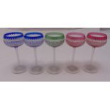 Five coloured hock glasses with faceted stems on circular spreading bases