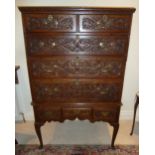 An early oak rectangular chest on stand, leaf and scroll carved drawers with brass swing handles