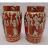 A pair of Kutani vases of cylindrical form decorated with figures within stylised leaf borders