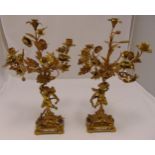 A pair of gilt metal five light candelabra, the cast angels supporting naturalistic floral arms with