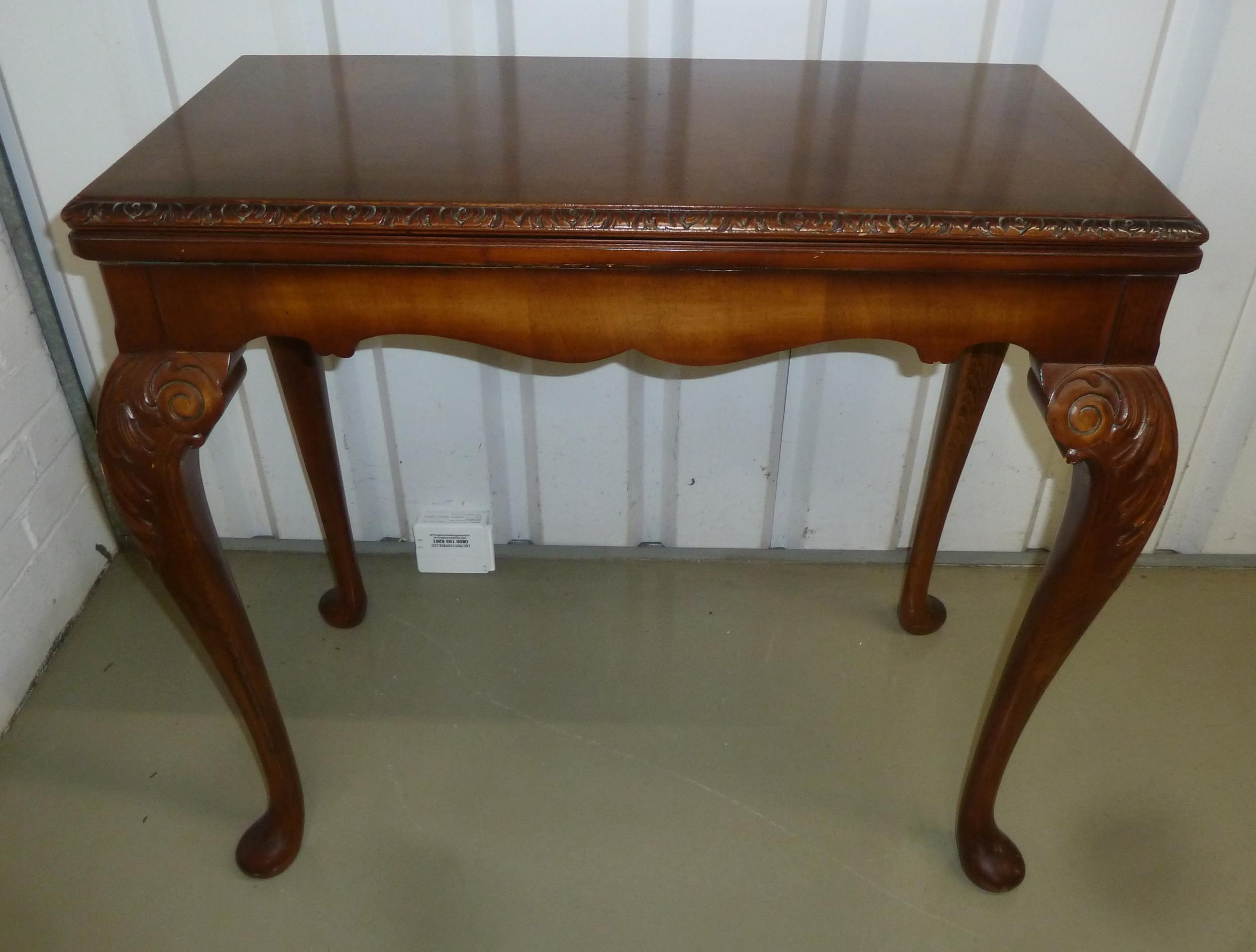 An Edwardian rectangular mahogany games table with gadrooned border on four leaf capped scroll legs,