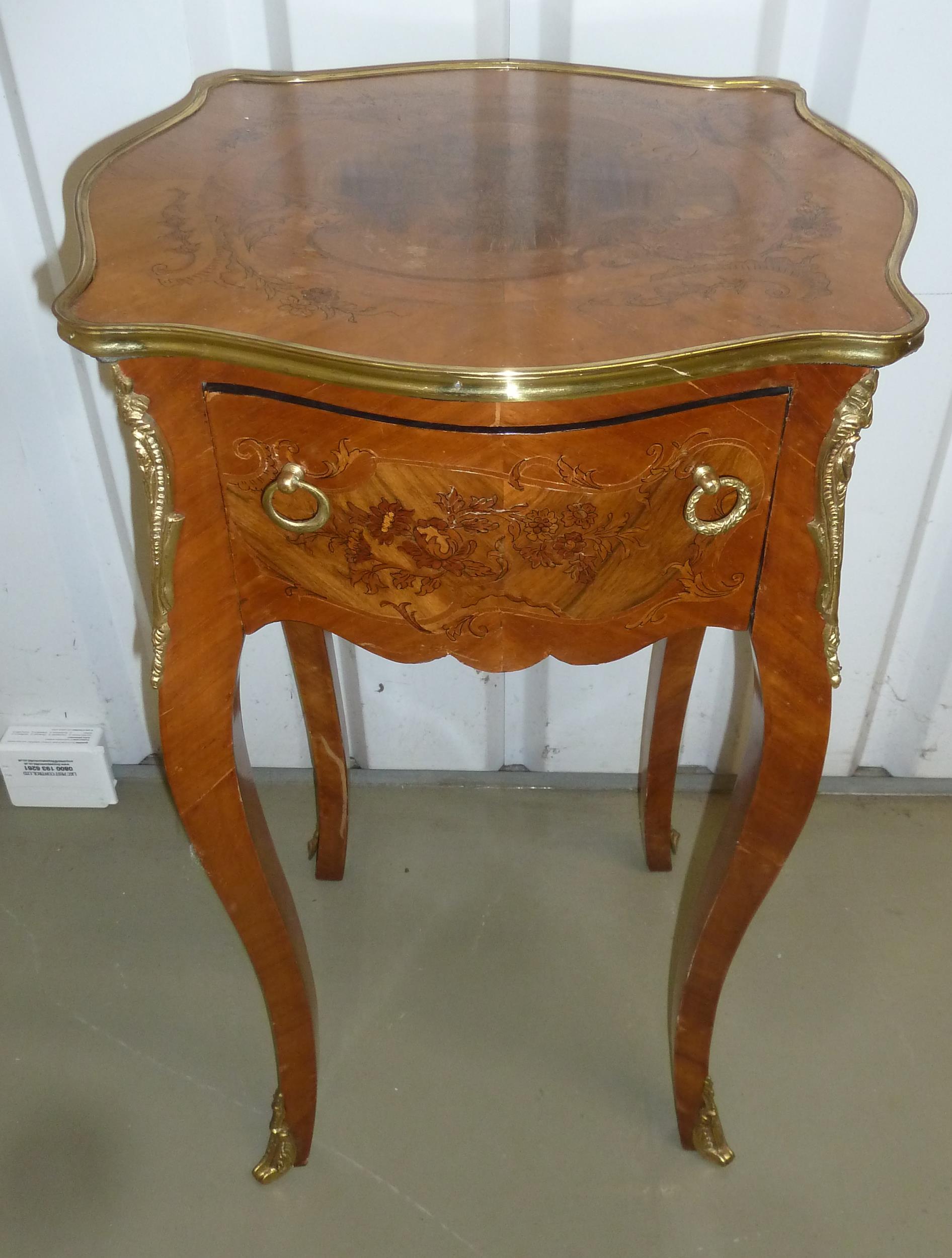 An inlaid mahogany rectangular side table with gilded metal mounts and a single drawer on four
