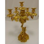 A mid 19th century Ormolu six light candelabrum with a putti supporting scrolling vine leaf arms and