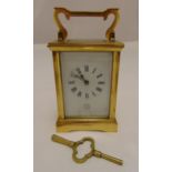 A Dent gilded metal carriage clock of customary form, white enamel dial with Roman numerals, to