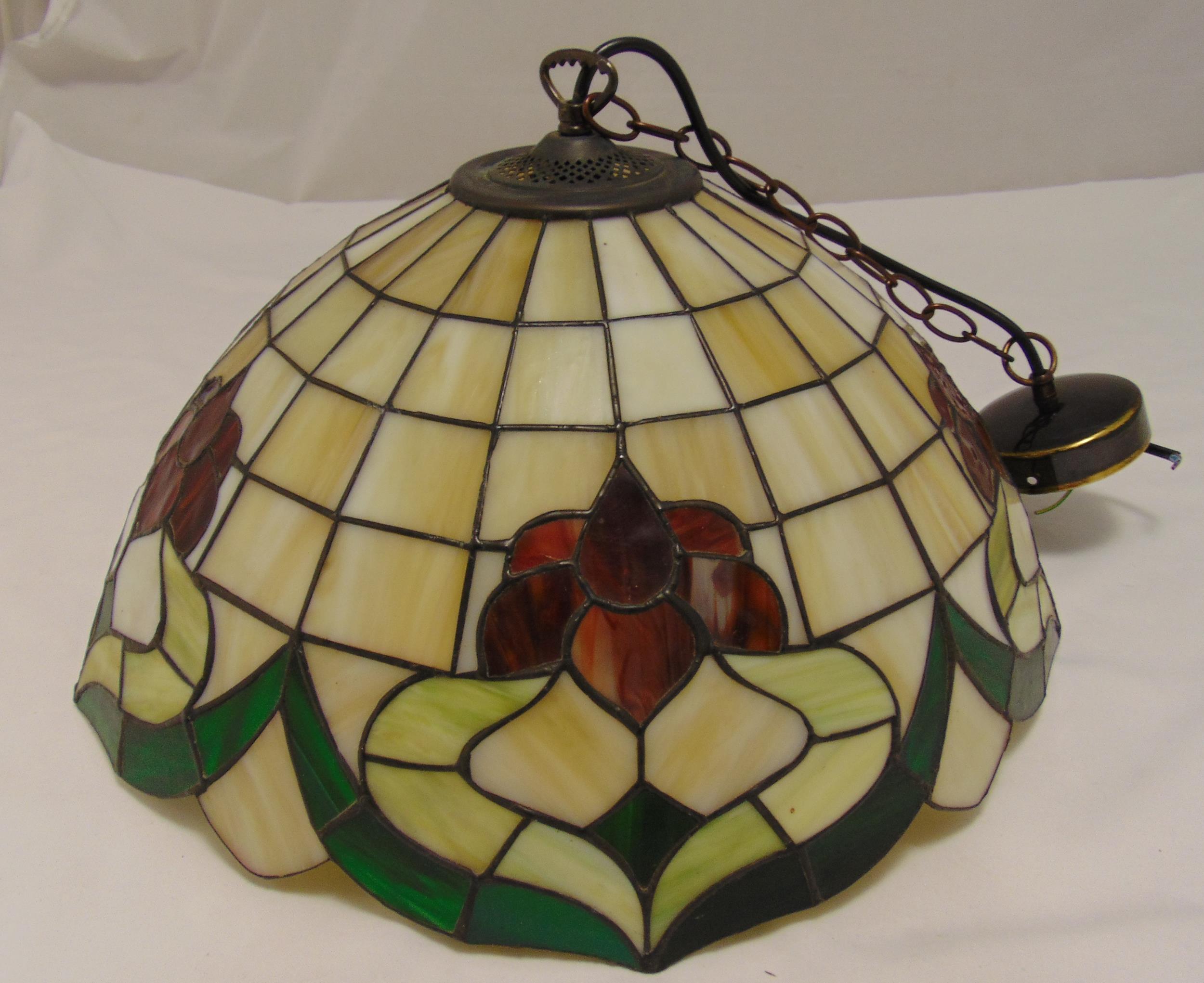 A Tiffany style ceiling lamp shade decorated with stylised flowers and leaves, 48cm (d)