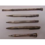 Four hallmarked silver propelling pencils to include one by Aspreys and a white metal pen holder (