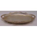A hallmarked silver oval gallery tray with scroll pierced everted border on four bun legs,