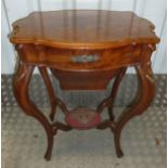 A Victorian mahogany sewing table of shaped rectangular form on four scroll legs, the hinged cover