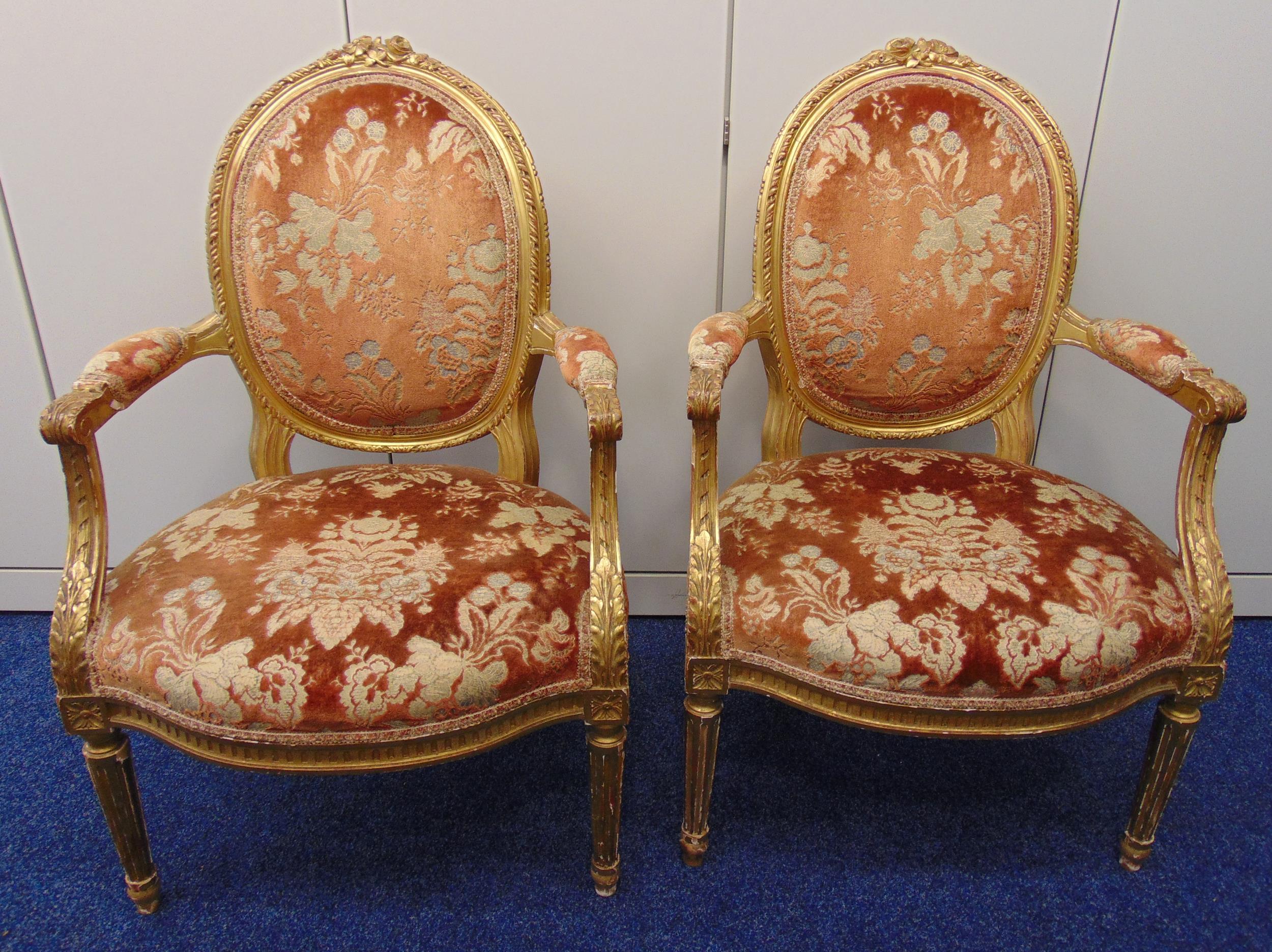 A pair of 19th century continental upholstered salon chairs, the legs, arms and backs carved with