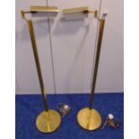 A pair of brass standard lamps, tubular with angled rectangular shades on raised circular bases,