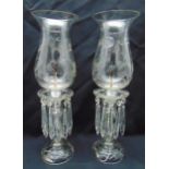 A pair of crystal storm lanterns with etched baluster shades on shaped stems with drops on raised