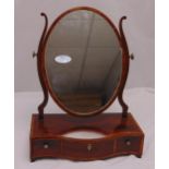 A Georgian mahogany oval dressing table mirror, the shaped rectangular plinth with three drawers