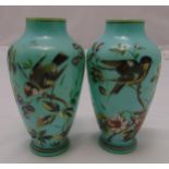 A pair of Victorian hand painted glass vases decorated with birds, flowers and leaves on raised