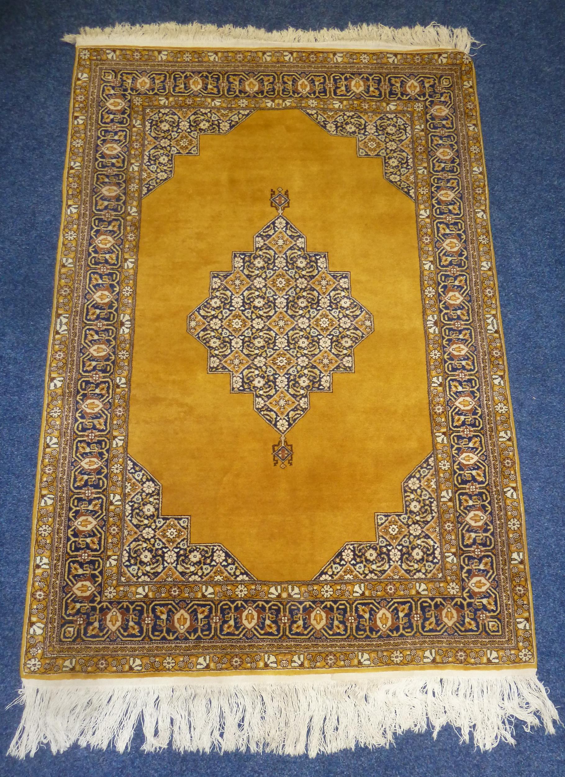 A Middle Eastern wool carpet brown ground with repeating geometric pattern and border, 162 x 111cm