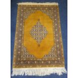 A Middle Eastern wool carpet brown ground with repeating geometric pattern and border, 162 x 111cm