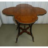 A continental quattrofoil tea table with hinged sides and decorative inlay on four cabriole legs,