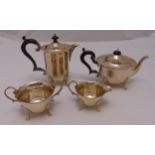 A hallmarked silver four piece tea set of cylindrical form with cut edge borders on leaf capped