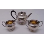 A hallmarked silver three piece bachelors teaset of bombe form with beaded borders, Sheffield