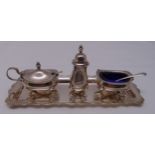 A hallmarked silver three piece condiment set on a matching rectangular stand, approx total weight