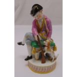 A Meissen 19th century figurine of a young boy with a play rifle and his dog, on raised circular