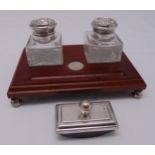 A hallmarked silver and mahogany desk stand with two glass inkwells and a hallmarked silver blotter