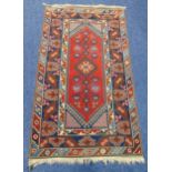 A Middle Eastern wool carpet blue and red ground with repeating patterns and border, 207 x 120cm