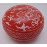 A Chinese porcelain circular temple box with pull off cover, red ground decorated with a dragon,