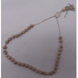 A white metal string of worry beads