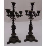 A pair of 19th century bronzed four light candelabra, the figural stems on raised triform bases,