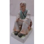 A Zsolnay Hungarian ceramic figurine of a seated peasant on raised rectangular plinth, 33cm (h)