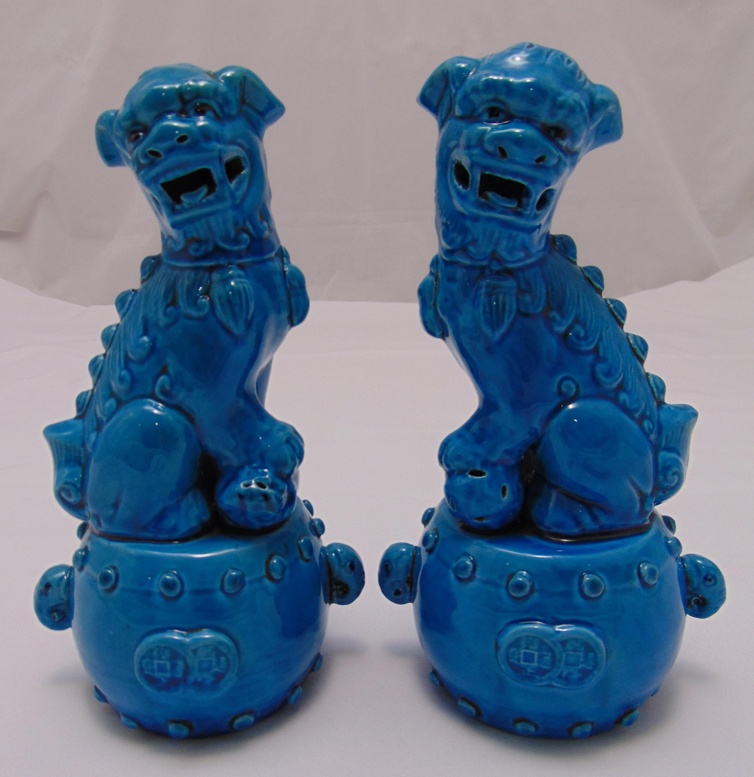 A pair of ceramic of Dogs of Foe, blue ground seated on raised circular bases, 23cm (h)