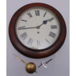 A circular oak cased waiting room clock with white enamel dial and Roman numerals, to include key