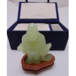 A carved hard stone figurine of a Buddha with hardwood stand in original fitted case, 10cm (h)
