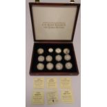 Twelve silver coins in plastic capsules to commemorate H.M. Queen Elizabeth and The Queen Mother