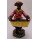 Majolica figurine of a Blackamoor holding a basket on a raised naturalistic base, 54cm (h)